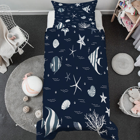 Navy blue bedding set with white sea creature patterns on a bed in a room.