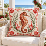 Seahorse coastal Christmas cushion cover on a white rattan chair on an ocean-view Christmas porch