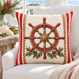 Ship’s Helm coastal Christmas cushion cover on a white reading chair beside a driftwood table
