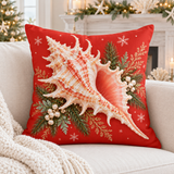 Coral-red Christmas murex shell cushion cover with evergreen and snowflakes styled in a coastal Christmas room
