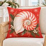 Coral-red Christmas nautilus shell cushion cover with evergreen and snowflakes styled in a coastal Christmas room