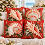 Four coral-red Christmas shell cushion covers with conch, scallop, nautilus and murex designs styled on an ivory sofa
